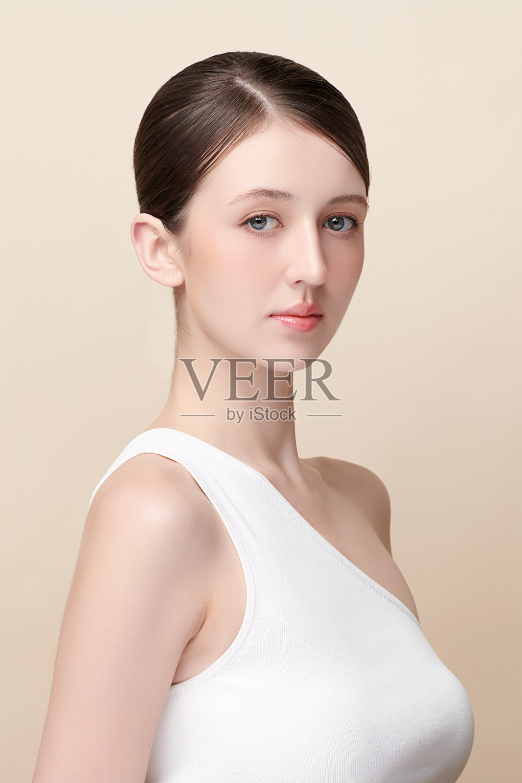 美丽的年轻女性，肤色洁净清新，背景为米色，面部护理，面部治疗，美容学，美容与水疗，女性肖像。照片摄影图片