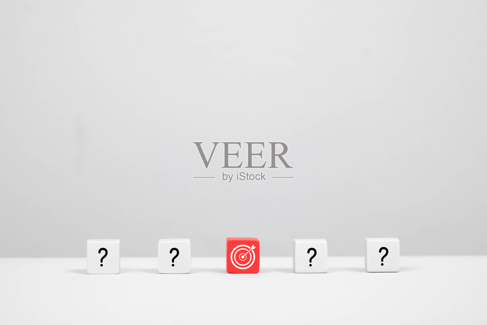 一个极简场景，红色靶块置于白色问号块之间，象征着专注与探究。照片摄影图片