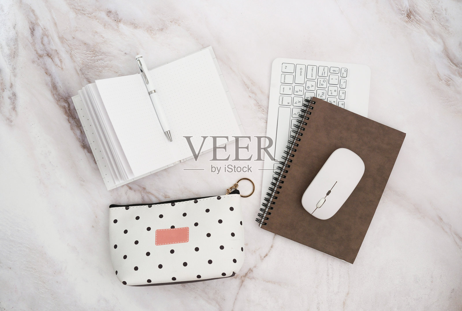 令人愉悦的文具摆放：钢笔、笔记本、化妆包、键盘和鼠标，提升了工作效率，激励着每一个人。照片摄影图片