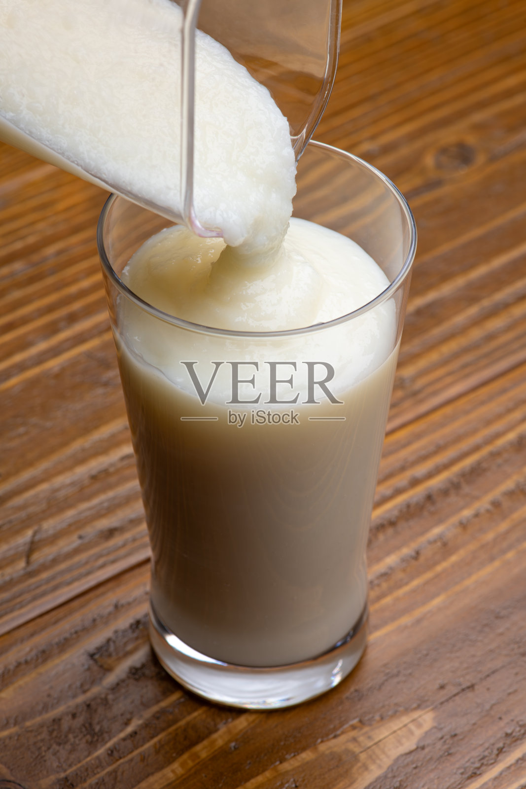 将奶昔倒入玻璃杯中照片摄影图片