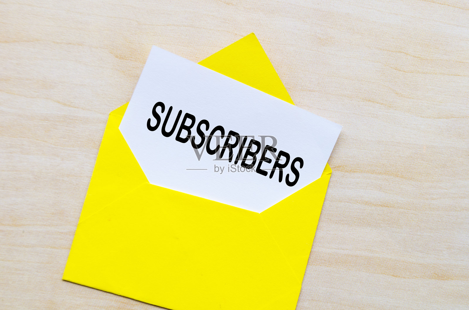 黄色信封内的白色记事本上的“订阅者”文字。在线赚钱概念照片摄影图片