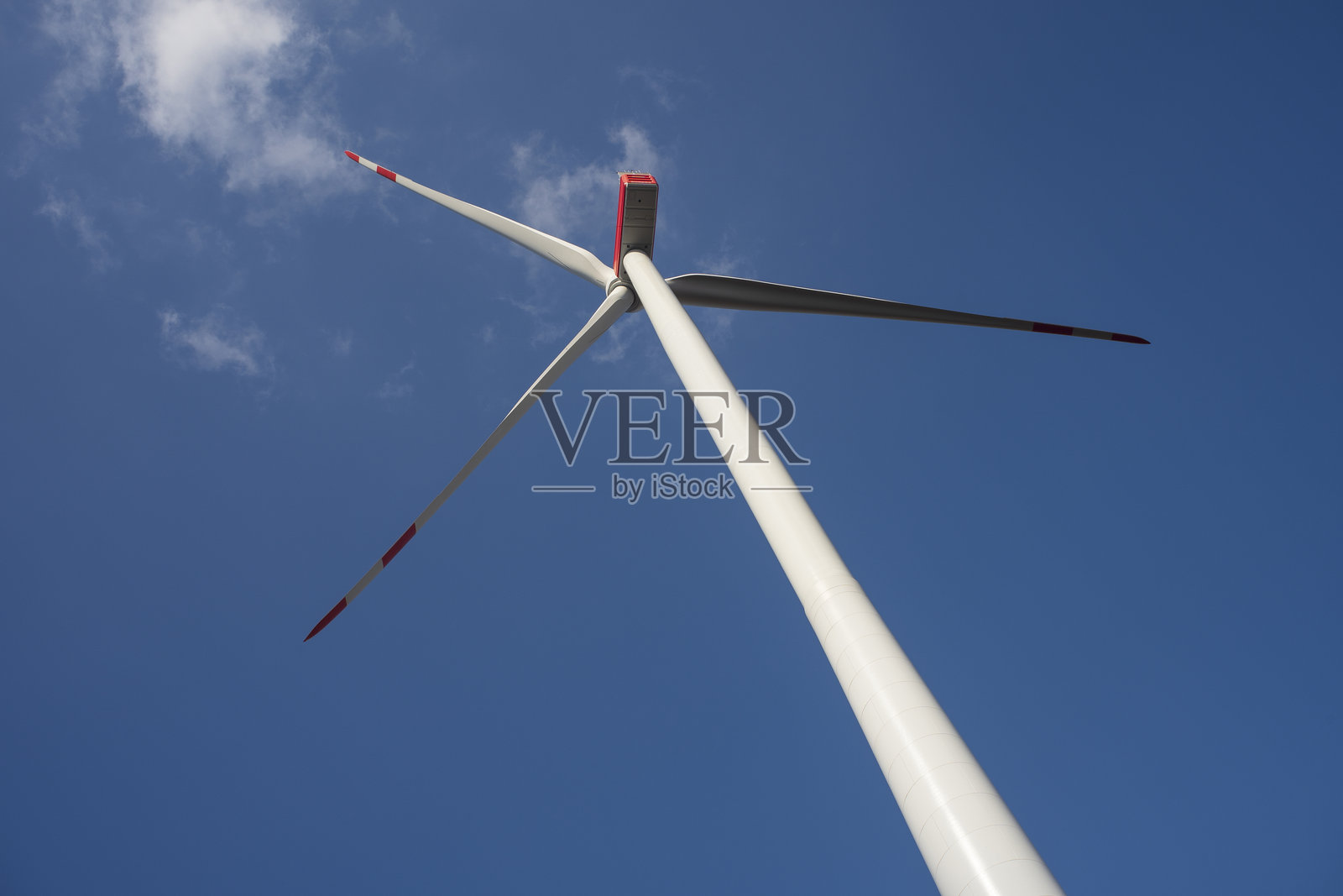 一座风力涡轮机在蓝天和白云下。清洁能源的概念。照片摄影图片