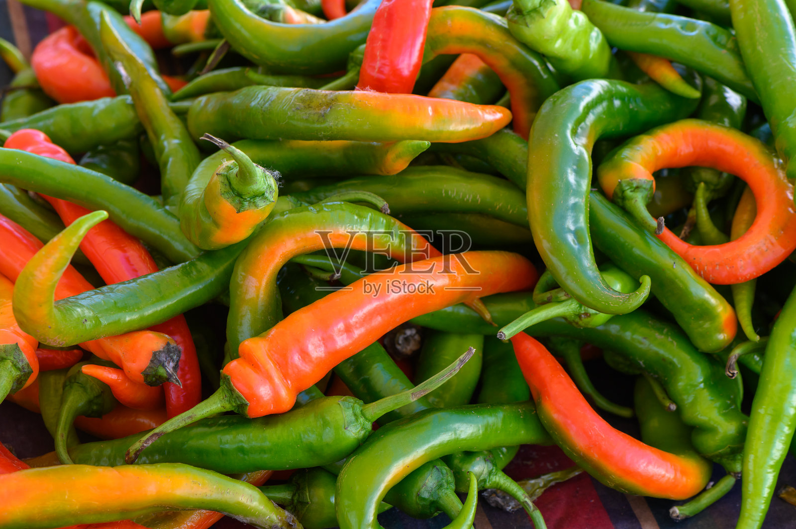 色彩缤纷的辣椒组合，来自清晨阳光下充满活力的市场，展示新鲜的农产品照片摄影图片