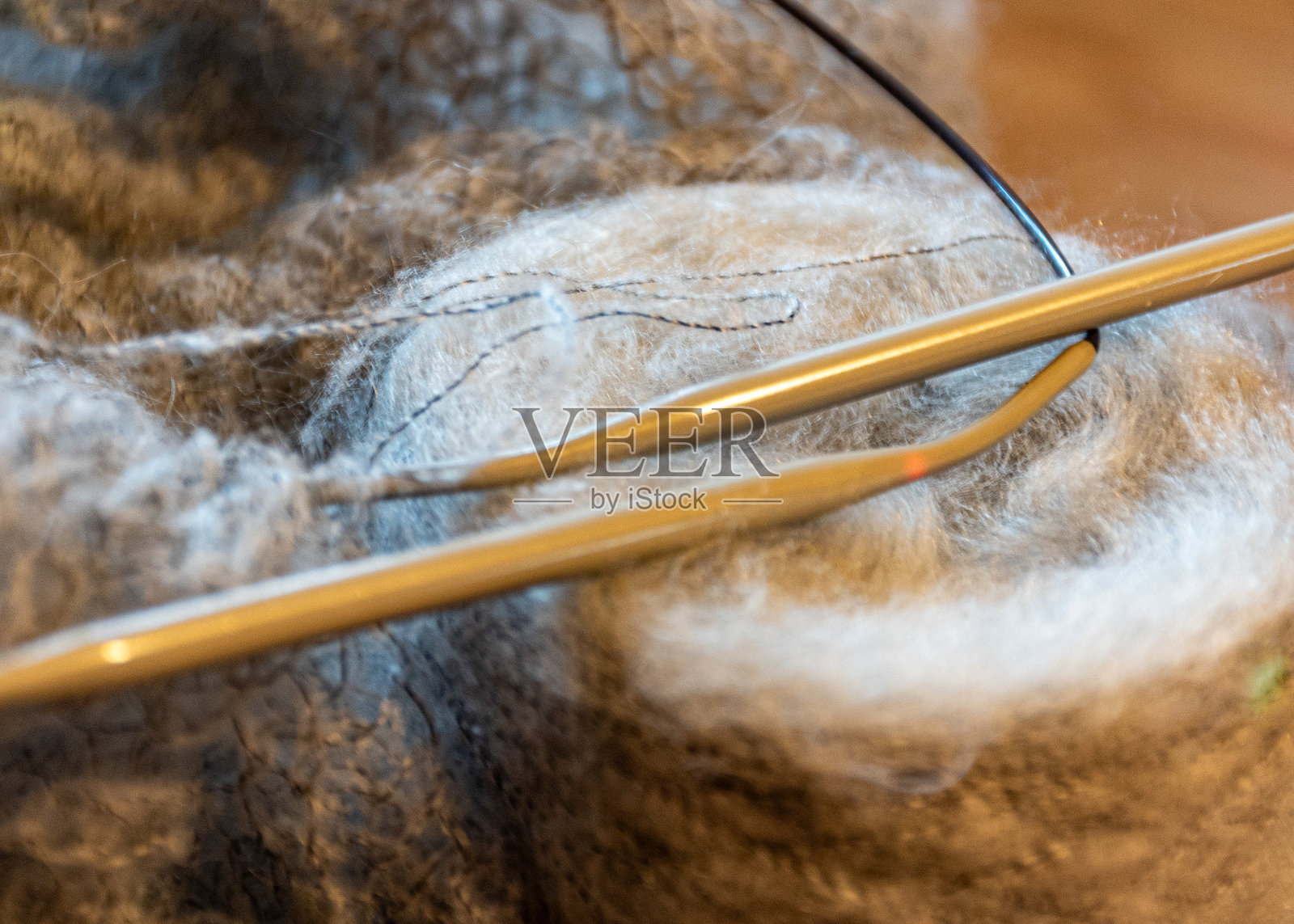 未完成的编织，舒适的家庭氛围，女爱好编织，温暖色调的纱线，纱线和针的特写照片摄影图片