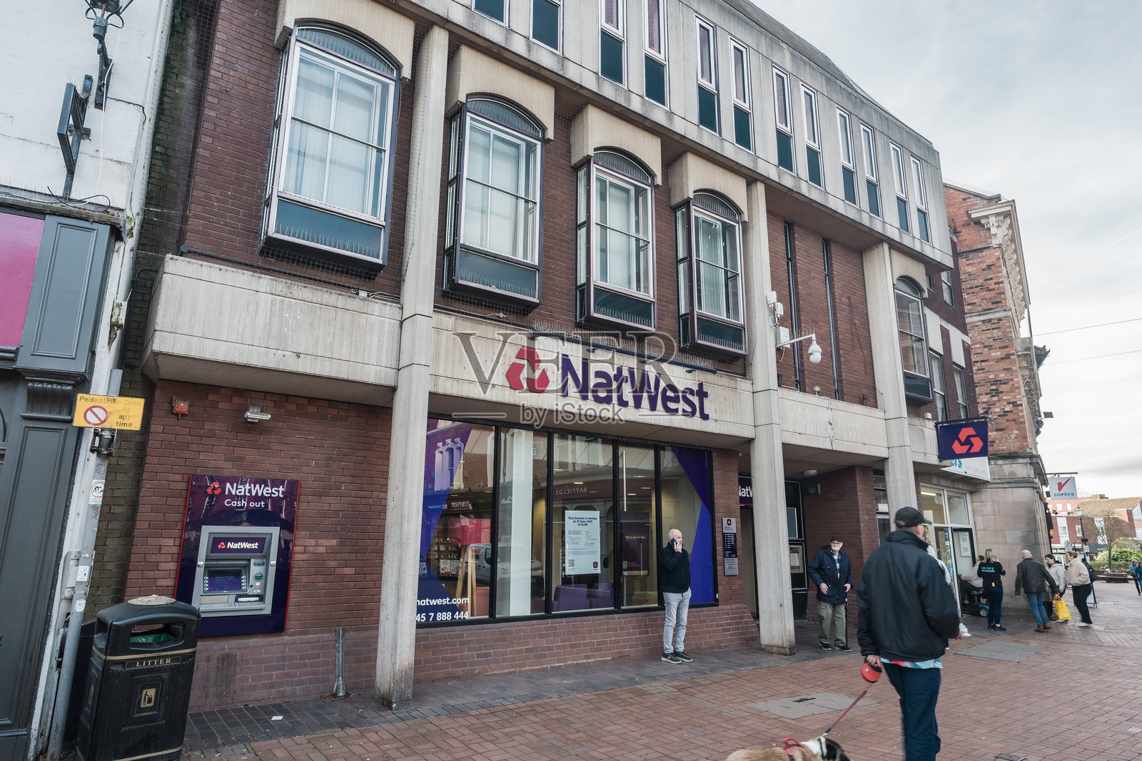 一个人走过高街上的NatWest银行的全景照片摄影图片