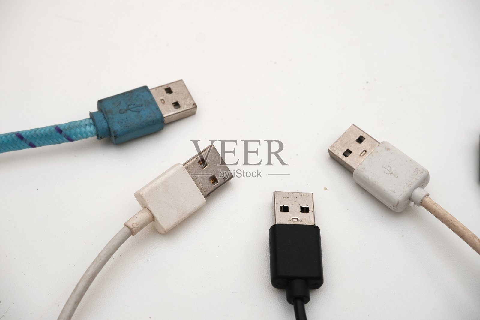 各种磨损状态的USB电缆集合，排列在白色背景上，完美适用于科技和维修主题。照片摄影图片