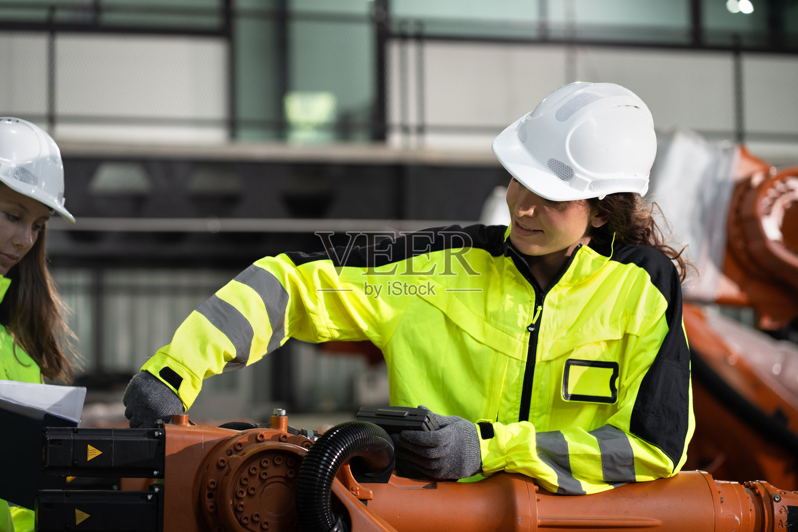 两名白人工程师在工厂检查和控制机械臂机器人照片摄影图片