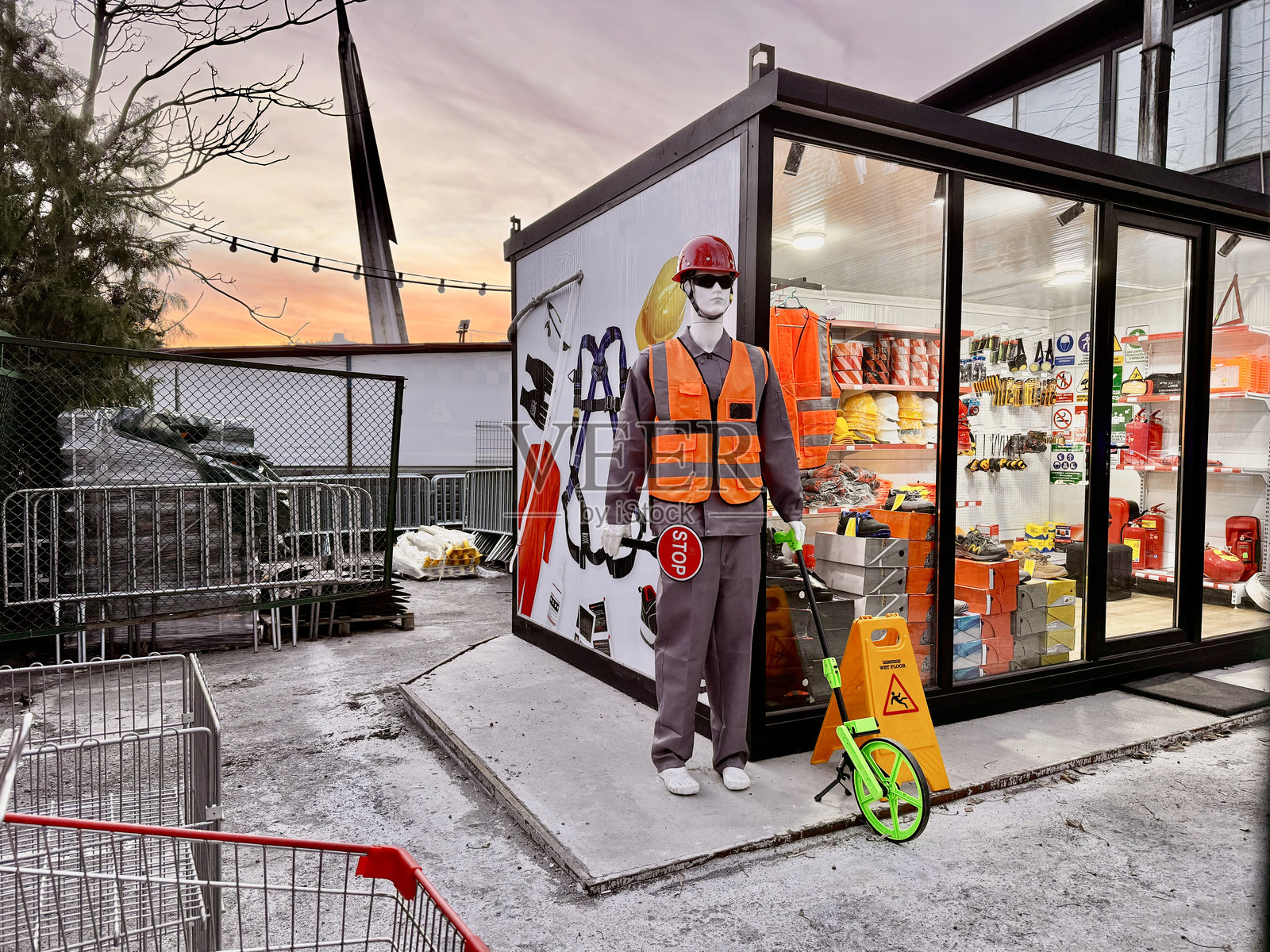 穿着安全装备的模特手持停车标志。道路配件商店。照片摄影图片