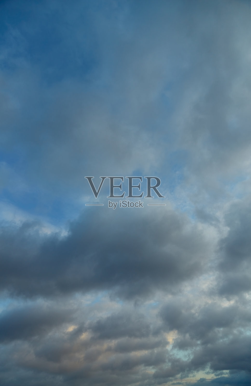 深灰色的云层营造出戏剧性的效果，让我们想起自然的力量。象征着不可逆转的过程和时间的自然流逝。照片摄影图片