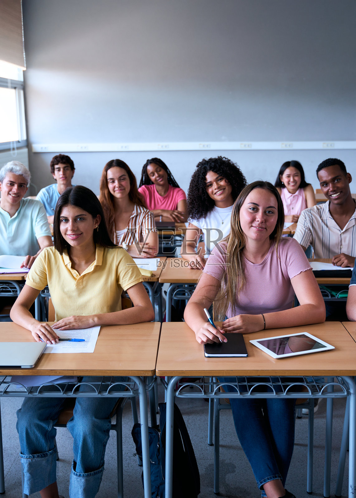 微笑的大学生群体坐在教室里看着镜头照片摄影图片