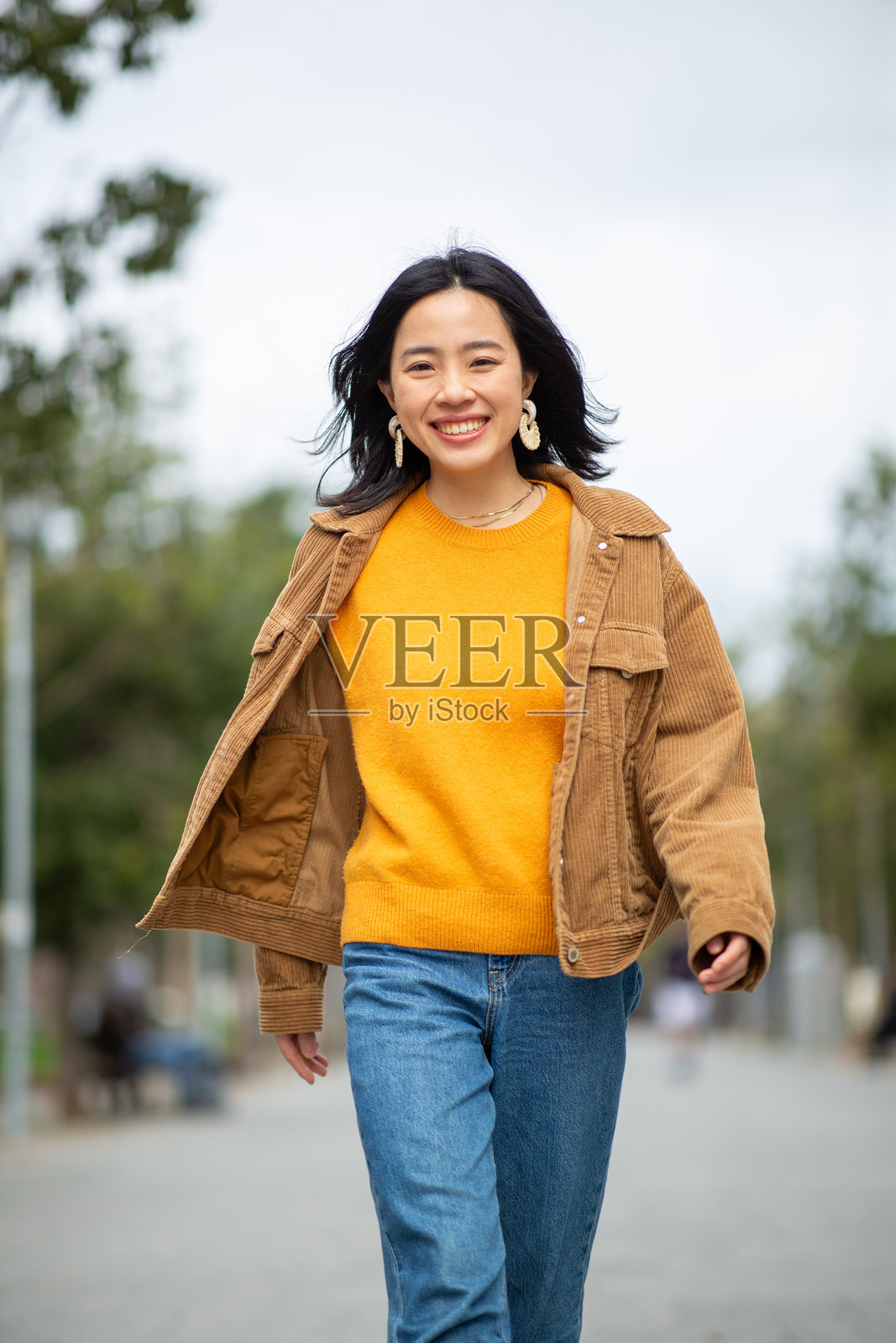 微笑的年轻女性在城市中行走照片摄影图片