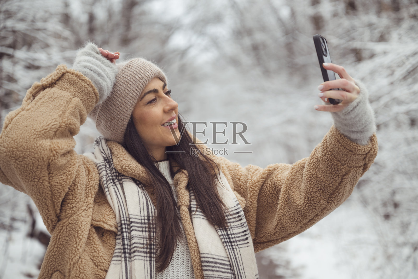 美丽的女人在冬季雪山中拍照照片摄影图片