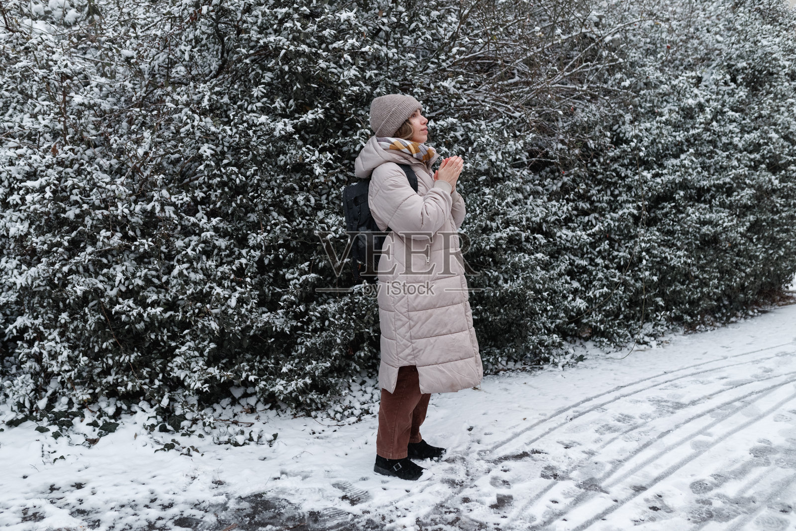 中年女性在冬天独自感到寒冷，抓起外套。照片摄影图片