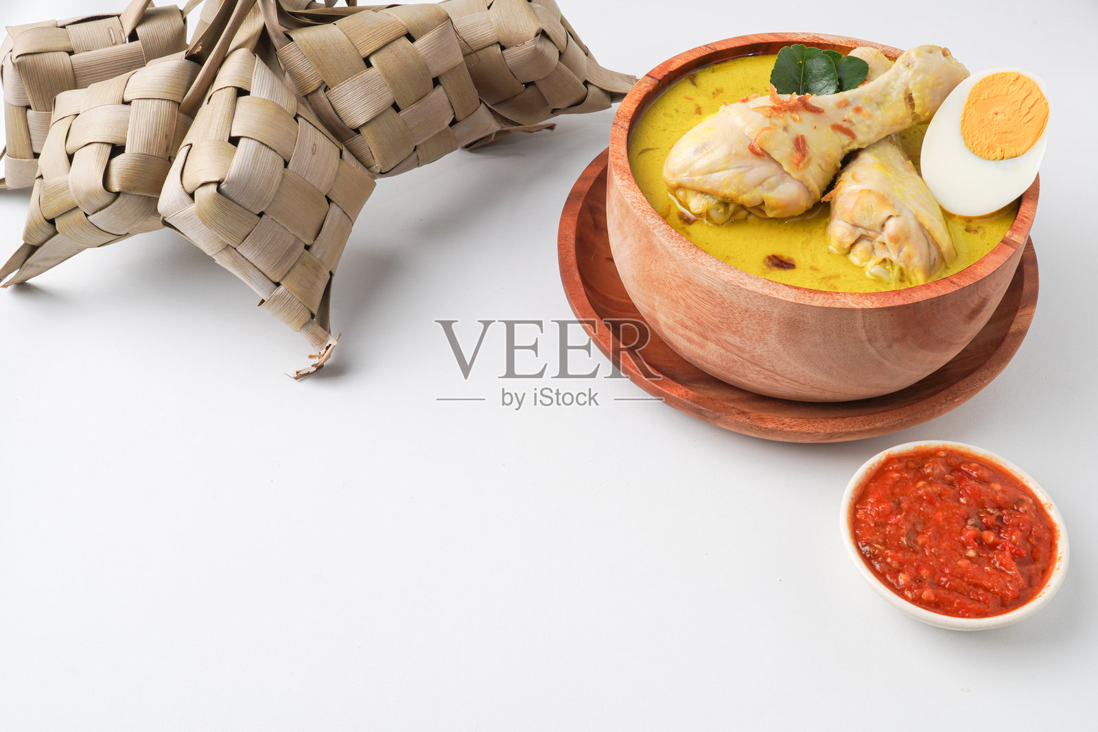 Lontong opor ayam 是一种印尼传统菜肴，通常在开斋节（Eid Mubarak）和开斋节假期庆祝时与 Ketupat Lebaran（米糕饺子）和 sambal 辣椒酱一起享用。照片摄影图片