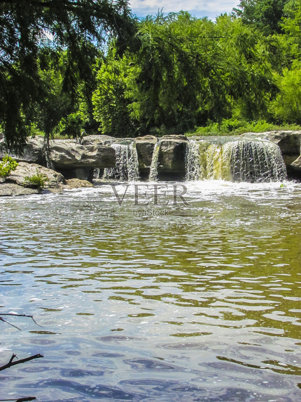 麦金尼瀑布的溪流中有一块大型灰色岩石的瀑布照片摄影图片
