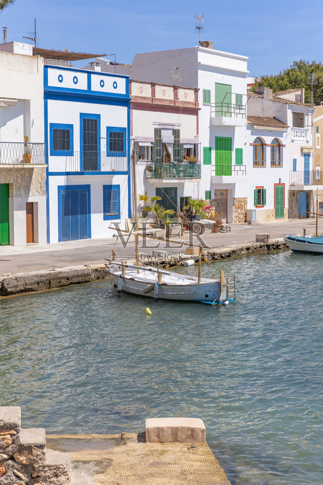 马洛卡的波尔托科隆港口，渔船与五彩斑斓的房屋照片摄影图片