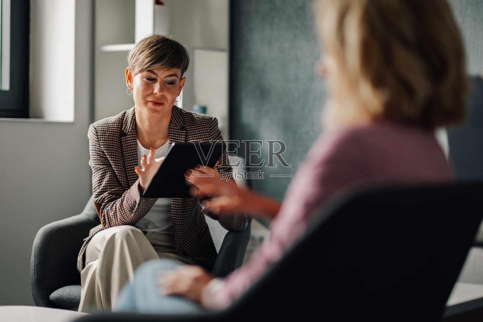 财务顾问向客户展示平板上的信息照片摄影图片