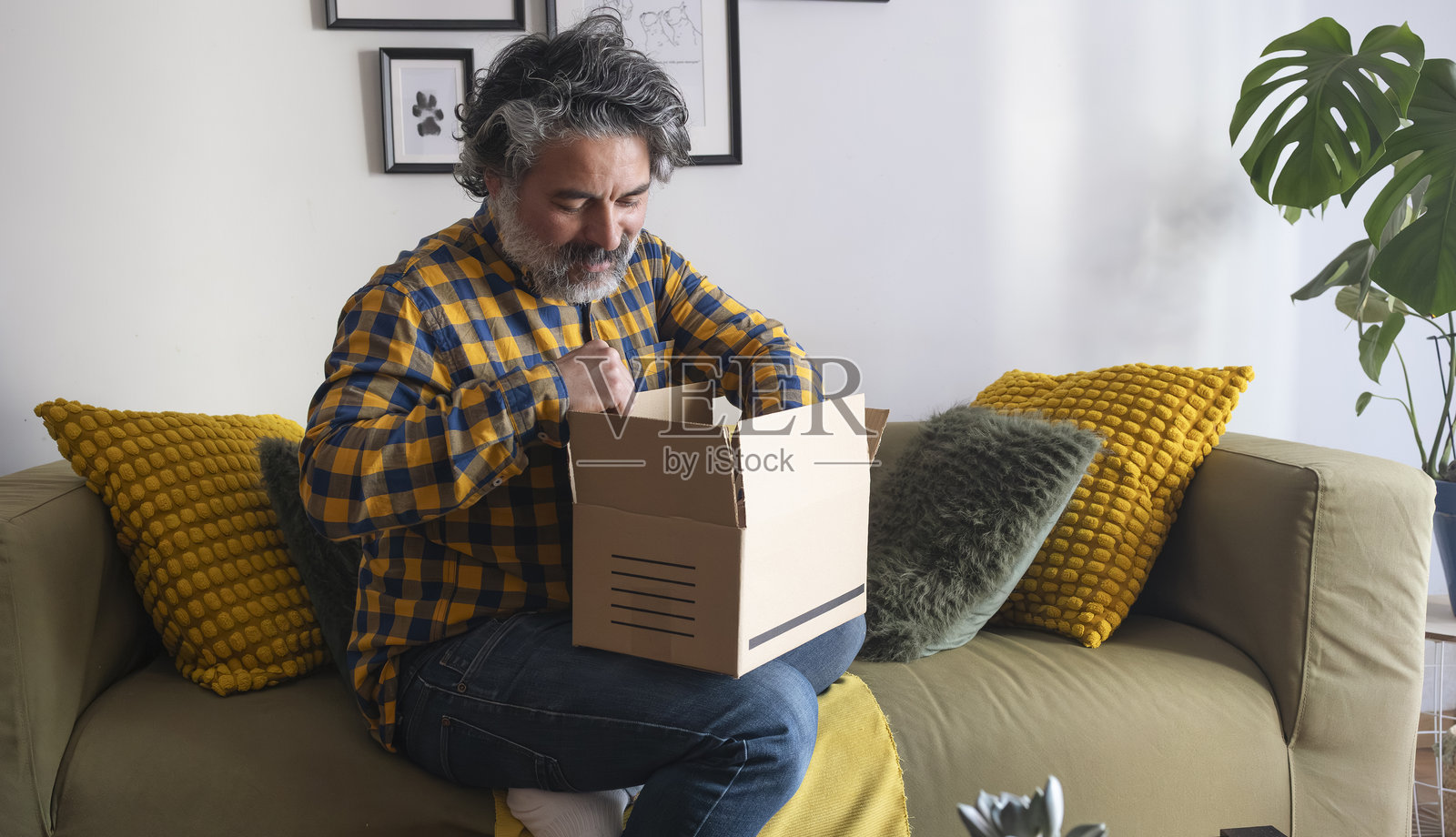 快乐的男人在家打开网购包裹照片摄影图片