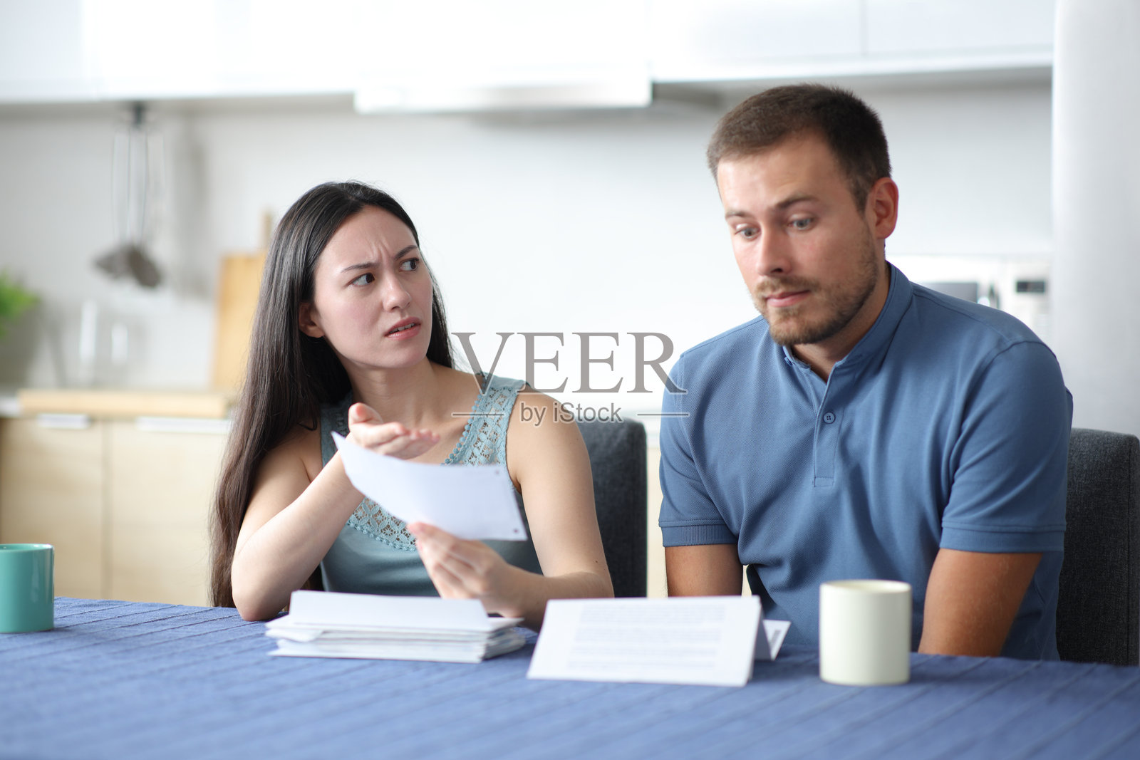 女人责备她的伴侣，展示有问题的发票照片摄影图片