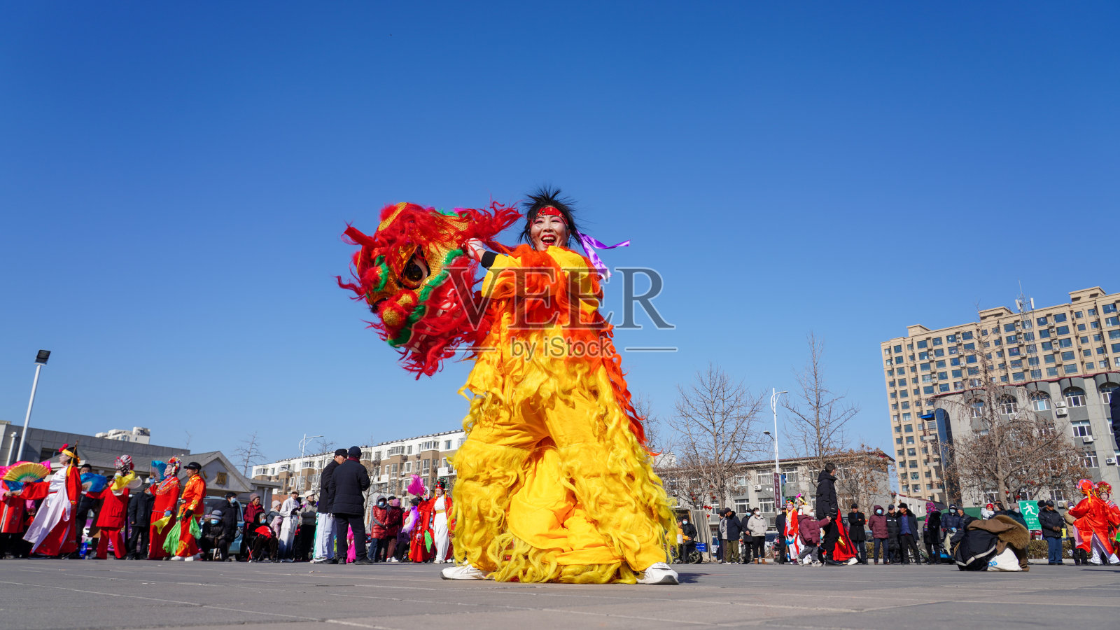 人们在广场上表演舞狮，以庆祝传统的中国节日——元宵节。照片摄影图片