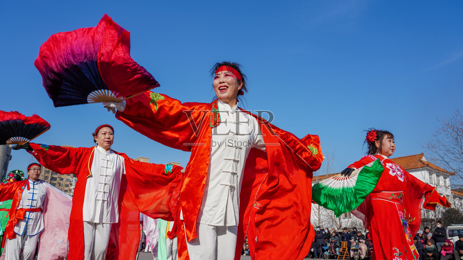 人们在广场上表演秧歌庆祝传统中国节日——春节。照片摄影图片