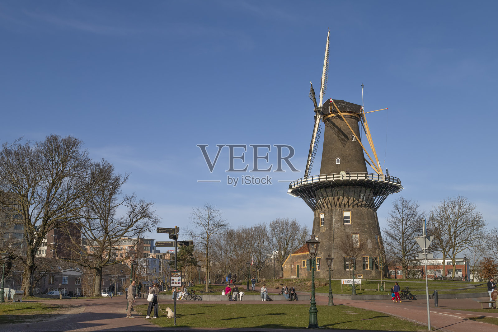 人们在莱顿的风车旁享受美丽的春季天气。照片摄影图片