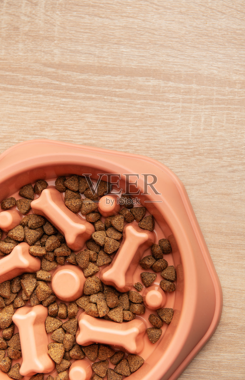 慢喂狗碗里装满了干狗粮，放在木桌上照片摄影图片