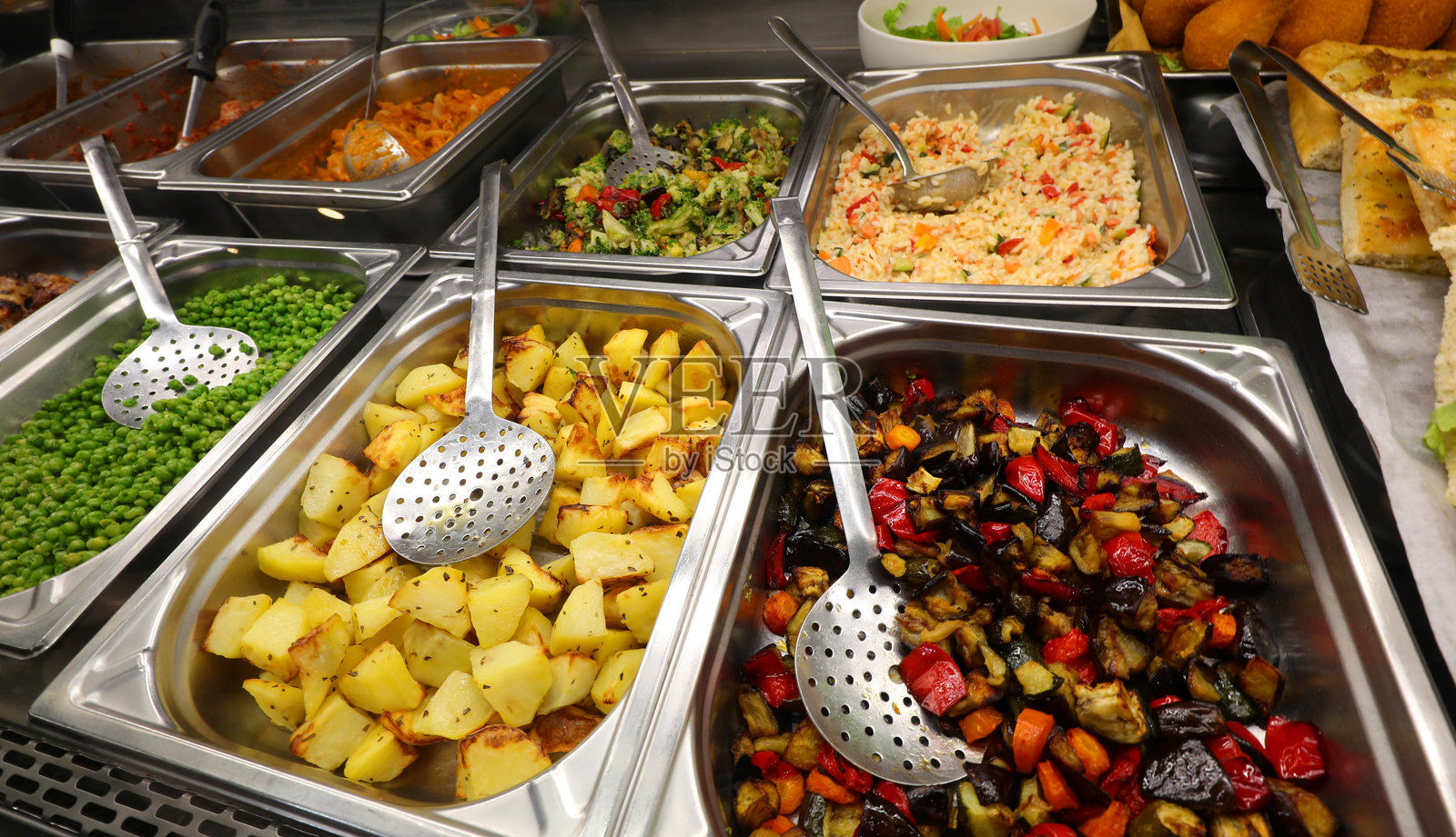 自助餐厅不锈钢托盘中的各种熟蔬菜照片摄影图片