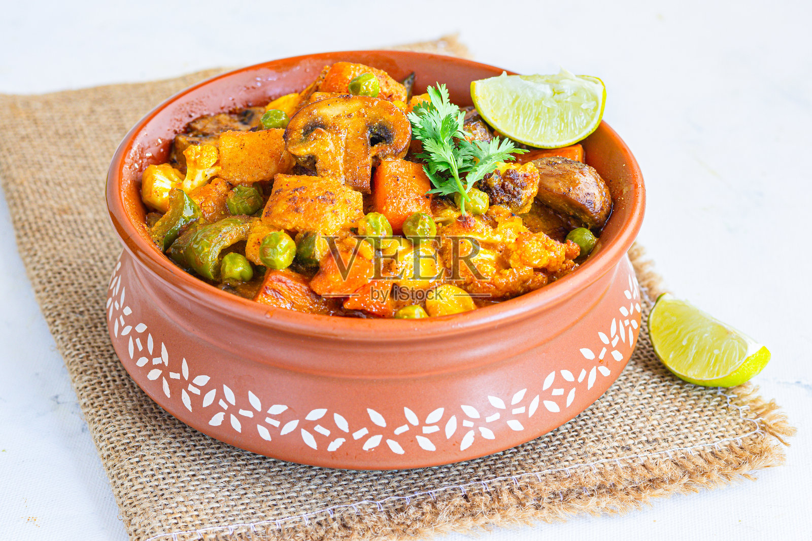 美味的混合蔬菜咖喱，配有土豆、胡萝卜、甜椒、青豆和花椰菜，照片正上方照片摄影图片