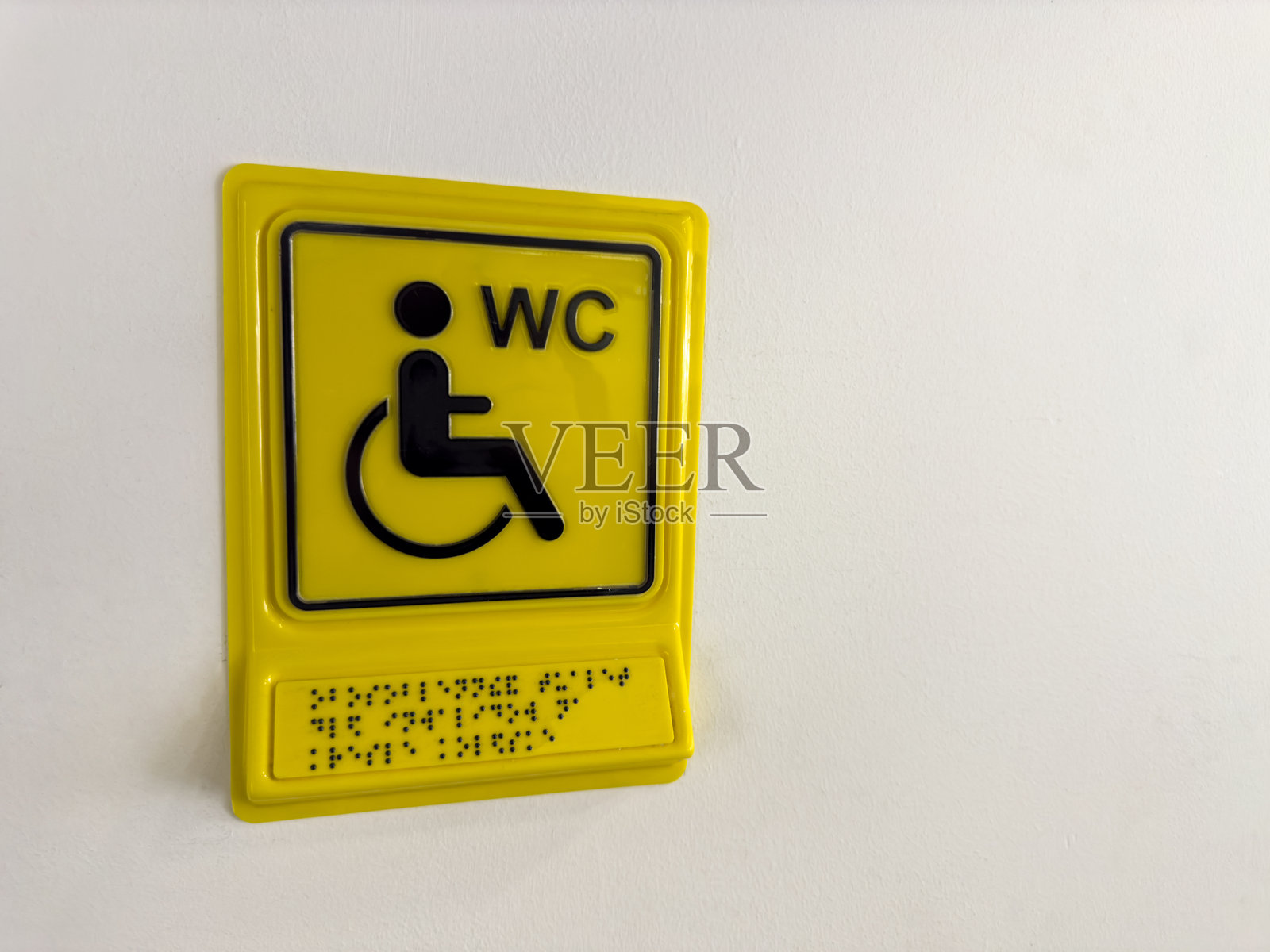 墙上带有盲文的标志，指示残疾人士的厕所位置照片摄影图片
