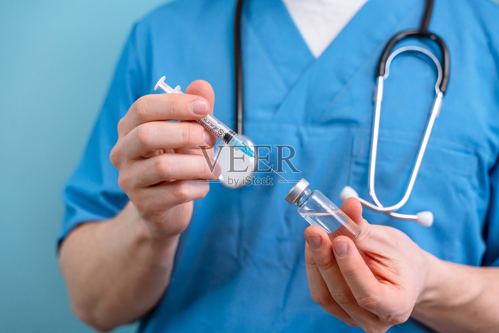 一名男医生正在用液体药物或疫苗填充注射器照片摄影图片