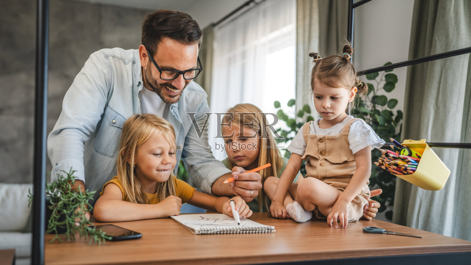 单身父亲帮助三个女儿做作业照片摄影图片