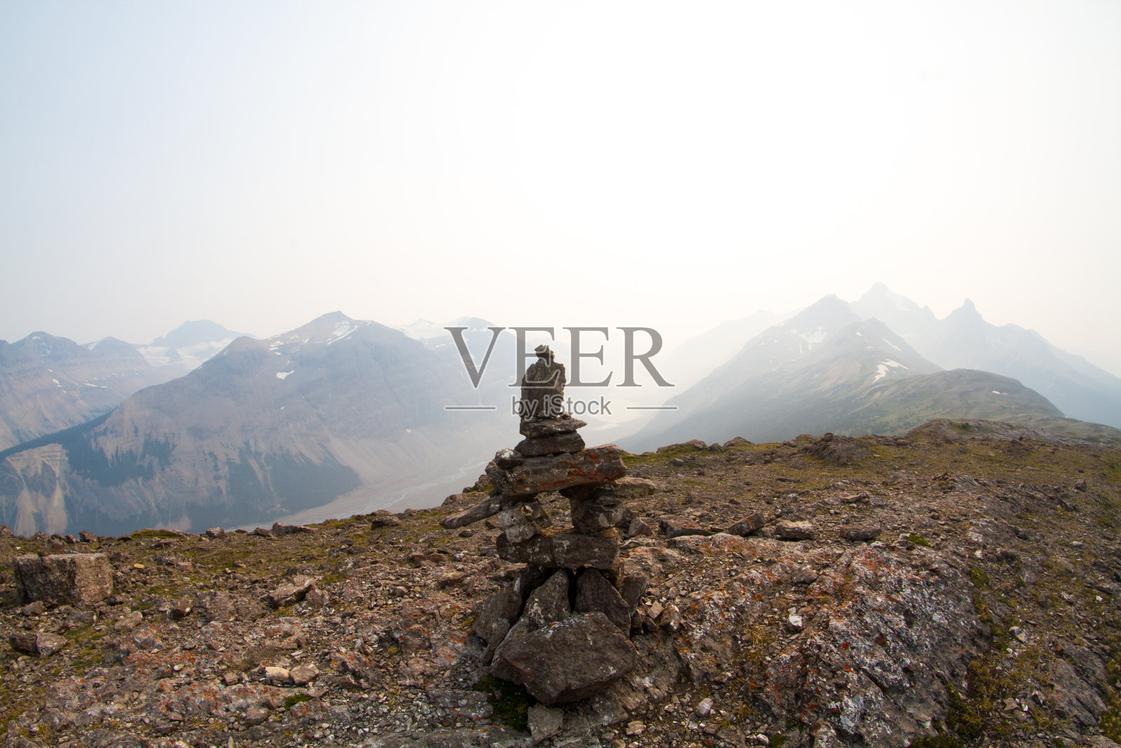 俯瞰壮丽山脉的因纽克石人照片摄影图片