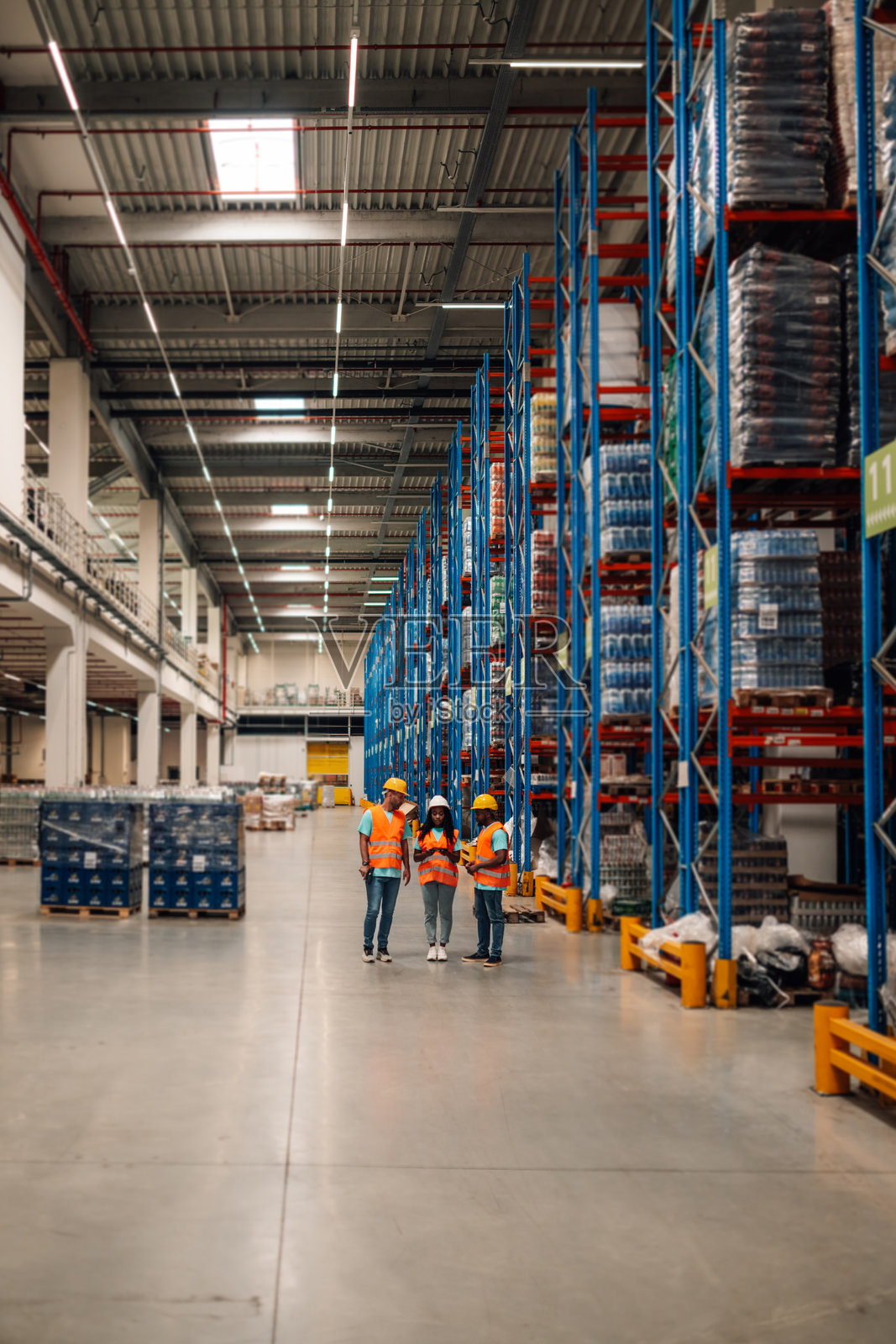 仓库工人在大型配送中心使用平板电脑讨论物流问题照片摄影图片