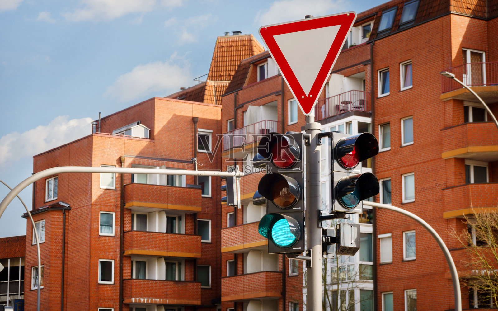 住宅建筑前的交通信号灯和优先标志照片摄影图片