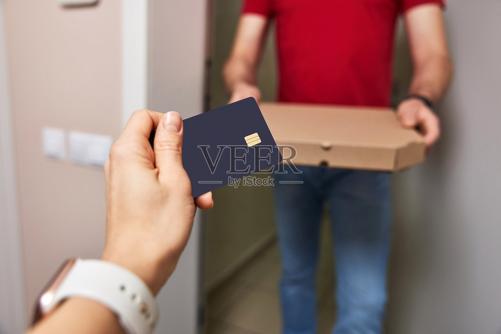 女人使用黑色信用卡支付送货员。照片摄影图片