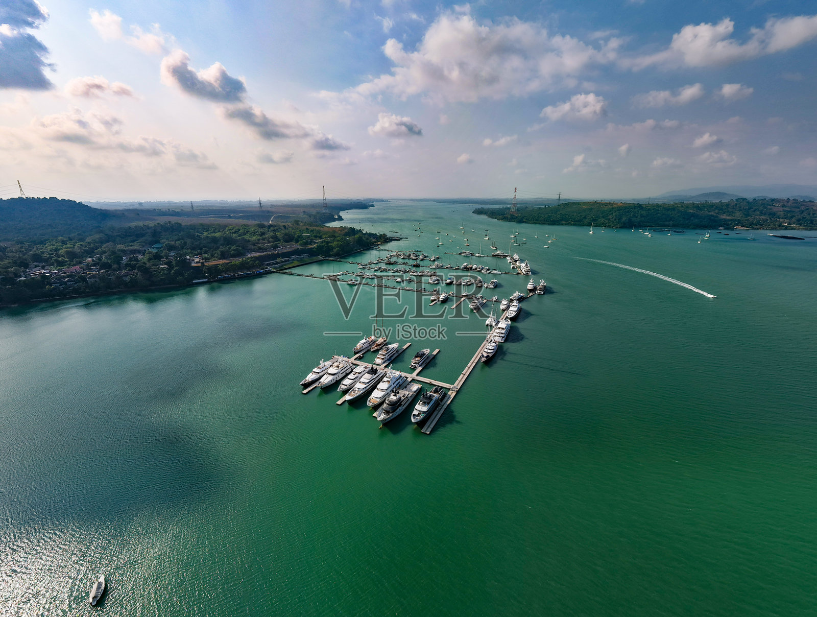 海港景观，停靠在碧绿水域的船只，风景如画的海岸线。照片摄影图片