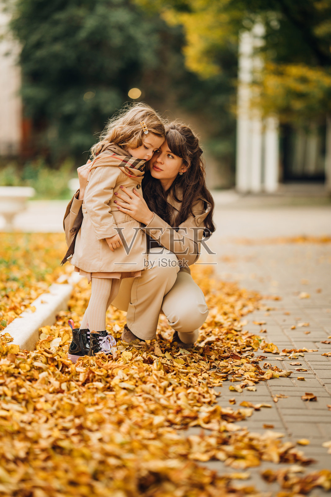 母女在满是落叶的公园里享受秋天的时光照片摄影图片