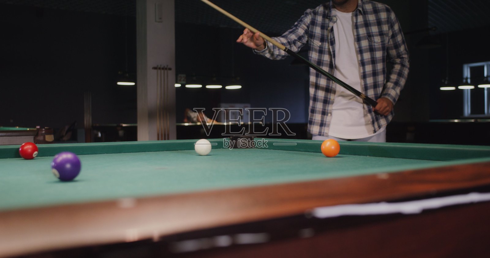 一个男人在台球俱乐部昏暗的灯光下独自打台球照片摄影图片