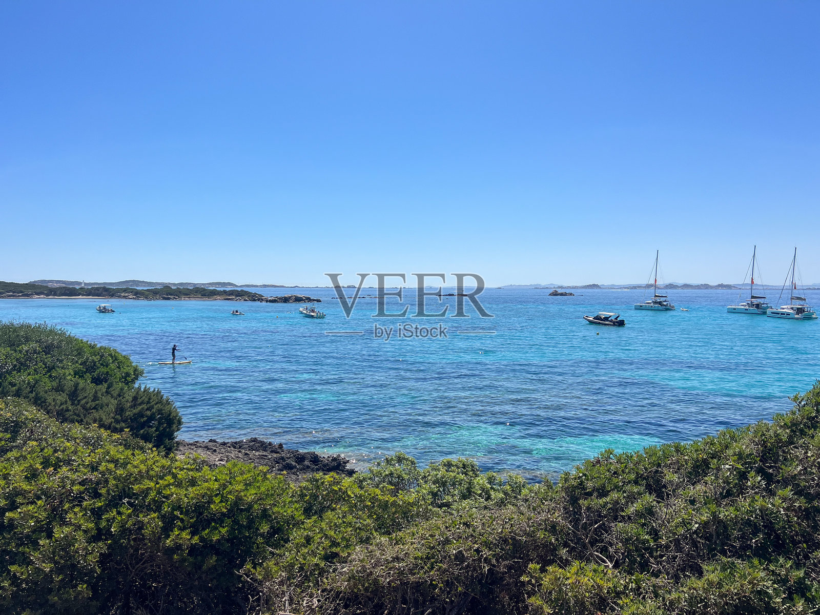 俯瞰宁静海湾和停泊帆船的海岸步道照片摄影图片