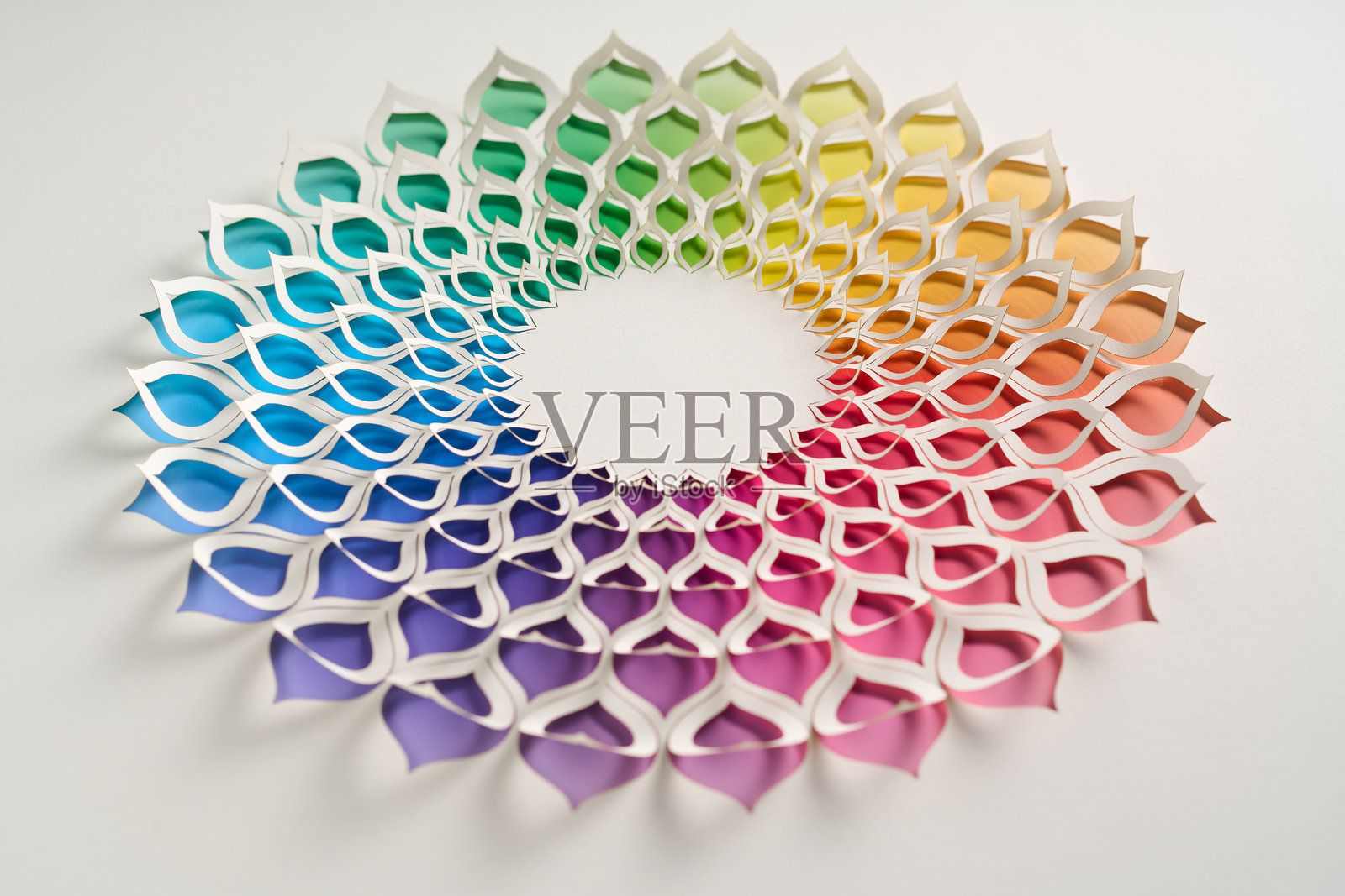 复杂的花卉曼陀罗纸雕，呈现出对称的图案，下面展现出鲜艳的彩虹渐变。照片摄影图片