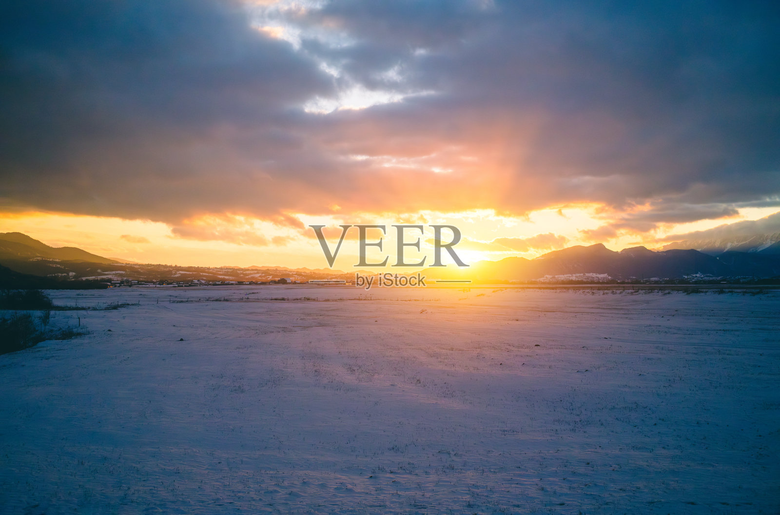 冬季雪地上的日落照片摄影图片