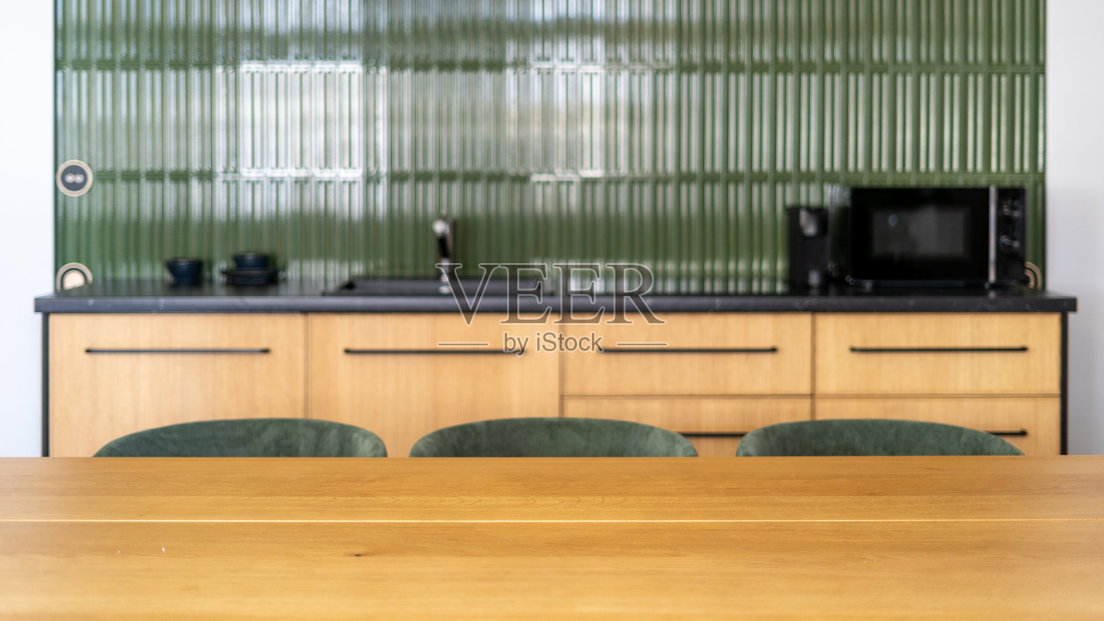 现代厨房内部，配有绿色点缀和光滑的木质家具照片摄影图片