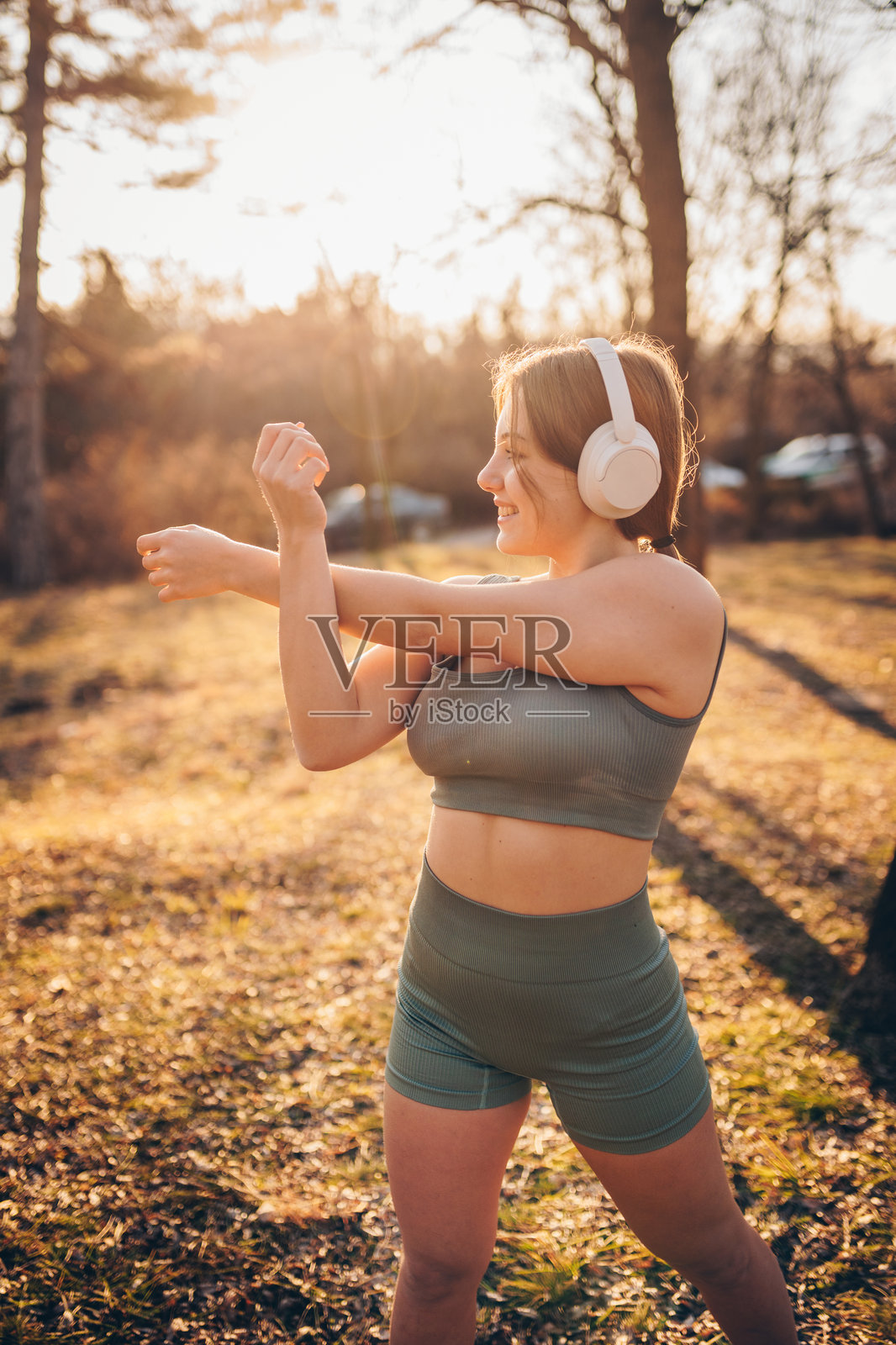 美丽的少女在公园里听音乐和锻炼。照片摄影图片