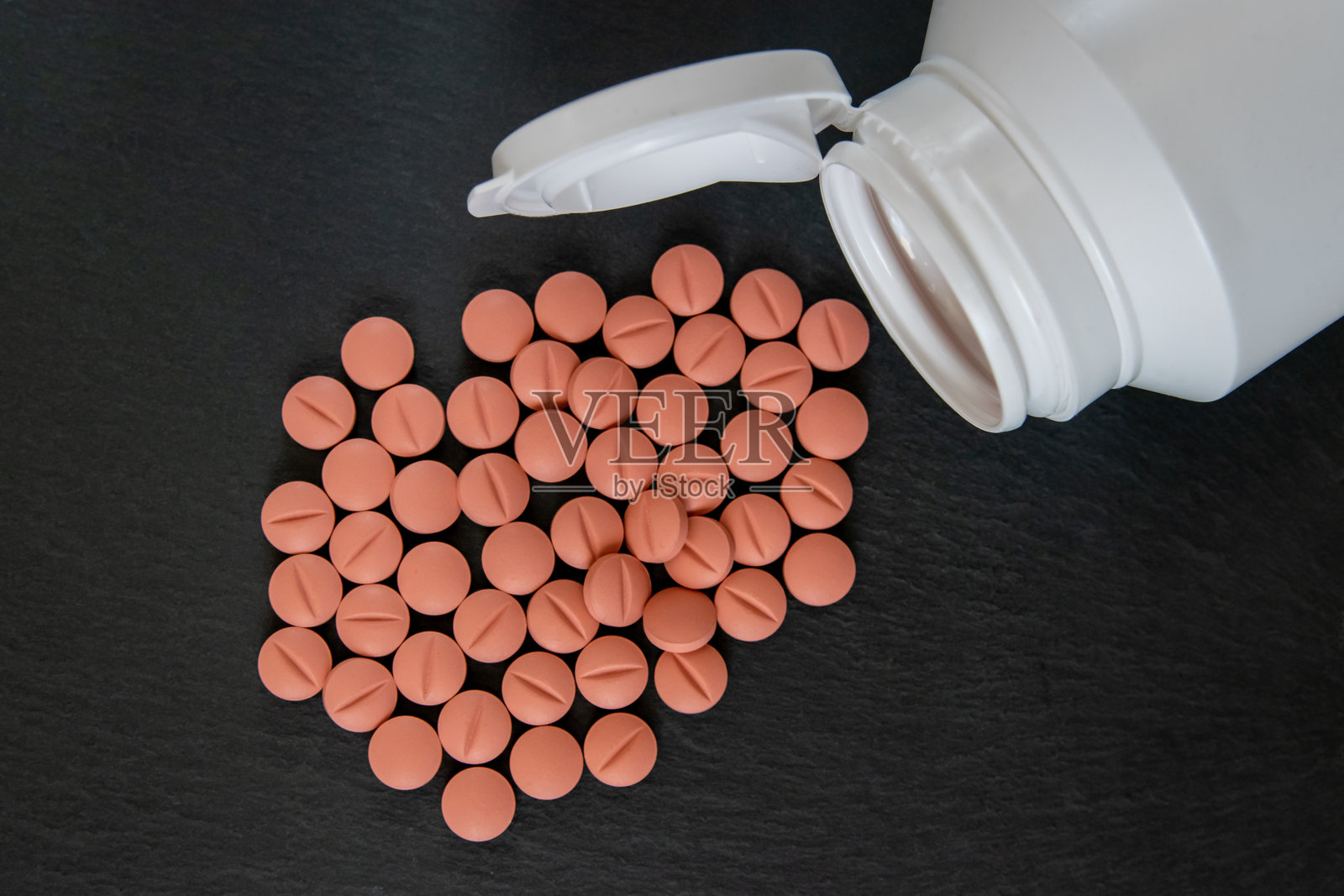 白色瓶子里的彩色药片或药丸。照片摄影图片