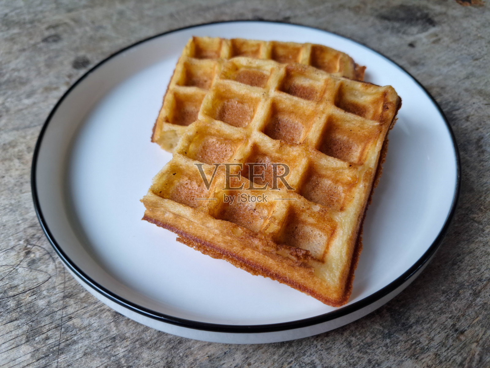 两块酥脆经典华夫饼放在盘子里。甜点菜单。照片摄影图片