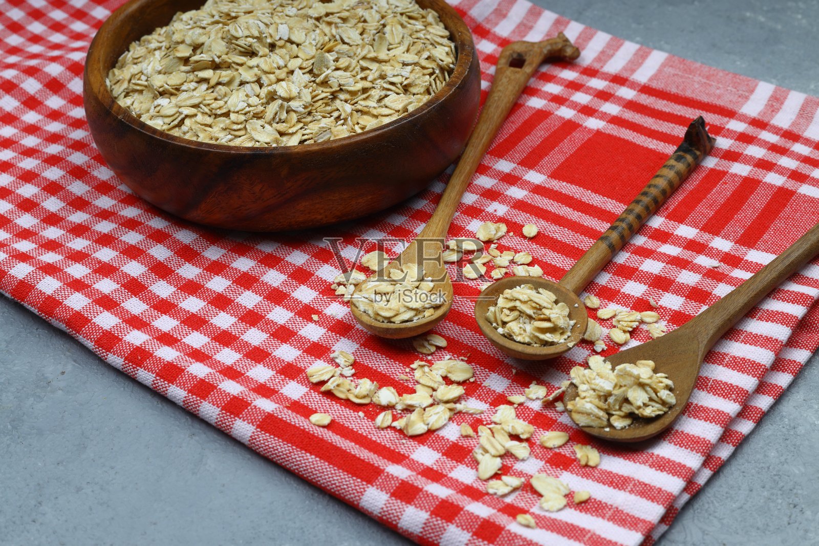 未煮的燕麦片放在木桌上的棕色碗里。健康的早餐食品照片摄影图片