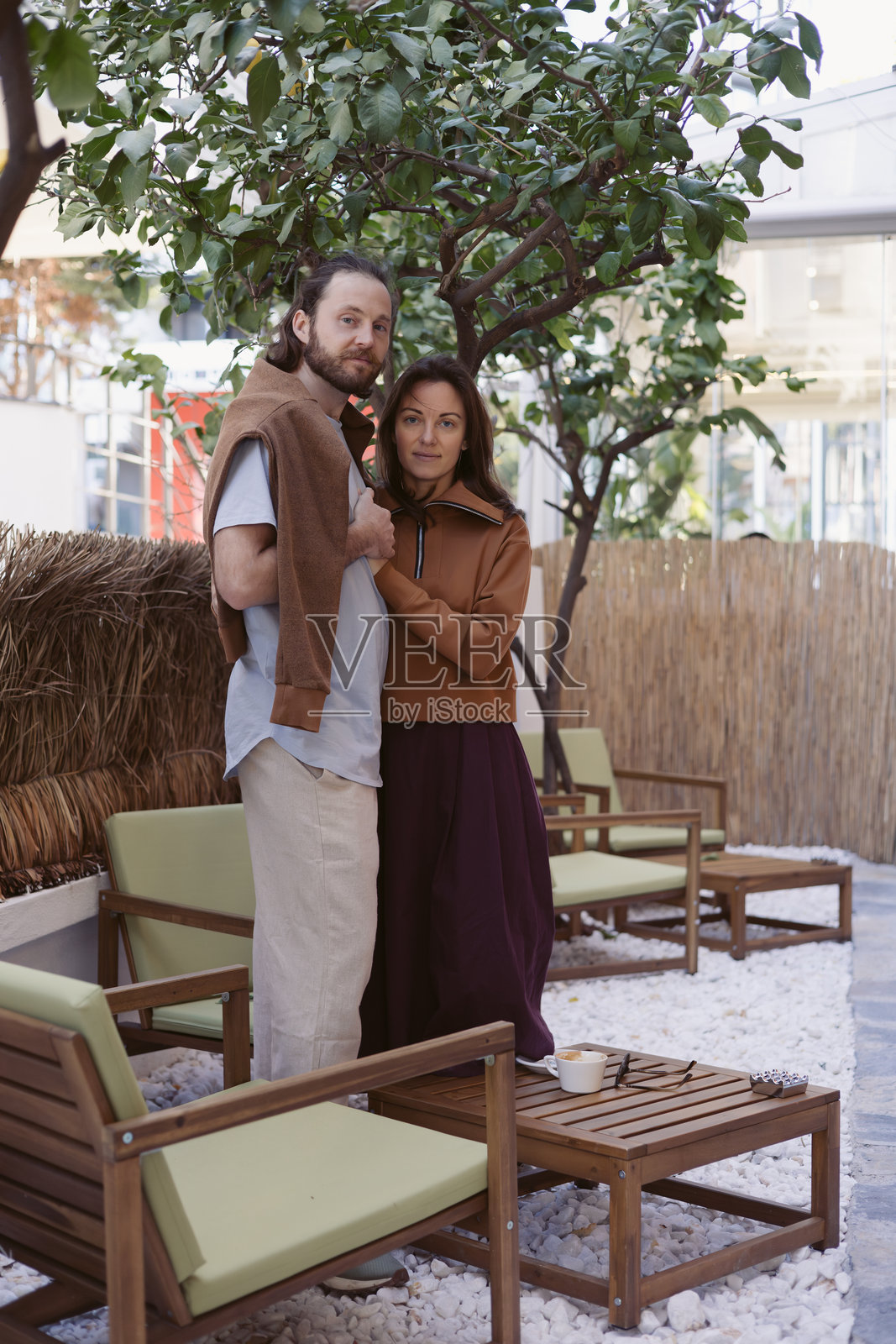 情侣在时尚的城市环境中，享受树下的温馨时刻照片摄影图片