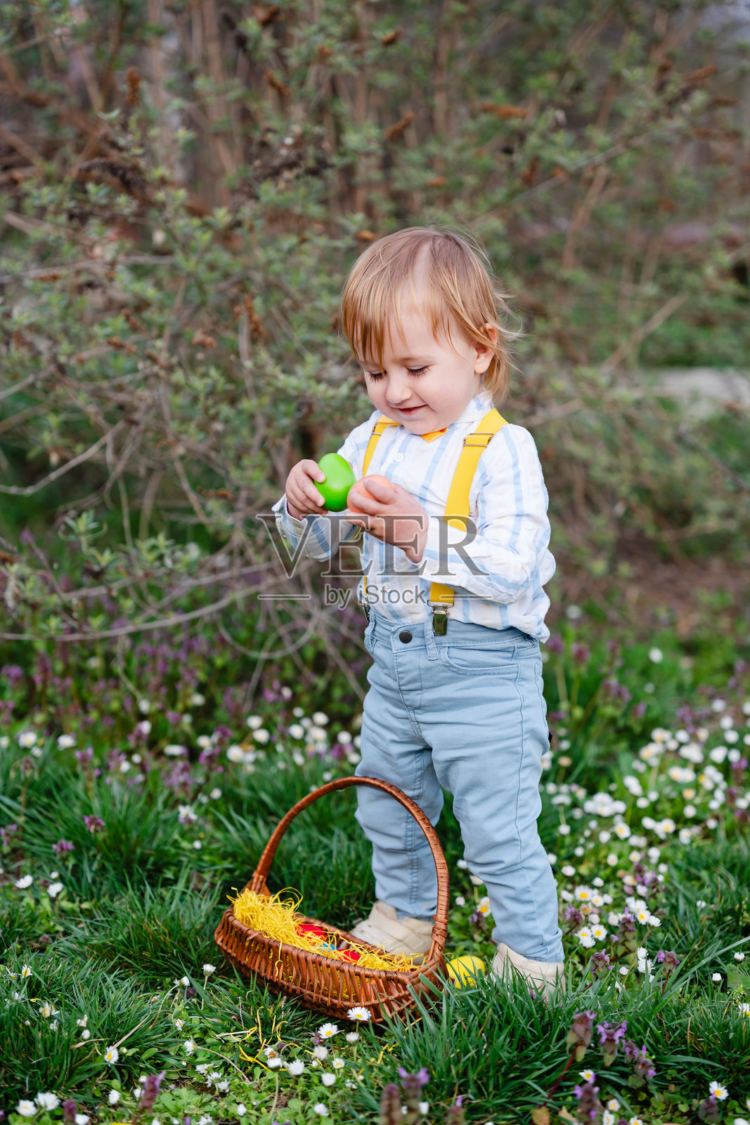 快乐的小男孩在公园里参加复活节彩蛋狩猎游戏照片摄影图片