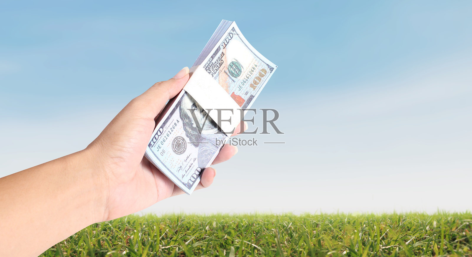 手握100美元钞票的美金现金，商业理念与金融、银行和投资的成功照片摄影图片